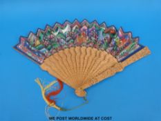 A carved Chinese sandalwood and painted fan in a lacquer box