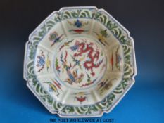 A Chinese octagonal bowl with scalloped and fluted edge and dragon and phoenix decoration (37cm