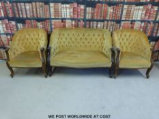 A three piece suite comprising two seat sofa and two chairs with show wood frame and carved front