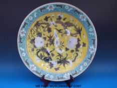 A 19thC Chinese charger with dragon and chrysanthemum decoration on a yellow ground.