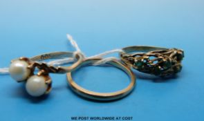 Two 9ct gold rings one set with emeralds and a yellow metal wedding band marked 10k gold