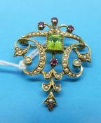 An Edwardian brooch / pendant marked 18ct set with a rectangular peridot surrounded by seed pearls