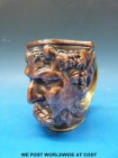 A brass and copper embossed Bacchus mug with grape vine decoration and sweeping handle to rear