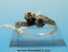 A yellow metal ring marked 18ct gold set with two diamond in a platinum twist setting with diamond
