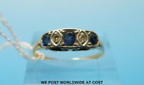 An 18ct gold ring set with alternating diamonds and sapphires (size S/T)