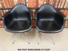 A pair of Charles & Ray Eames Herman Miller style chairs raised on chrome legs