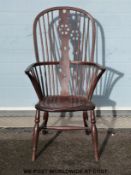 An elm seated Windsor armchair with cartwheel design to the pierced splat back