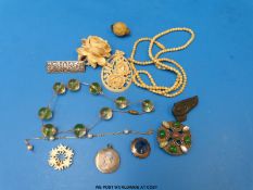 An ivory bead necklace, carved ivory brooch in the form of a rose, carved ivory pendant,