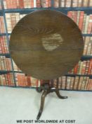 An oak tilt top table with bird cage movement on tripod base (H79,