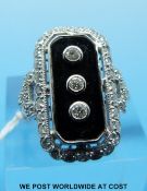 An 18ct white gold ring set with a rectangular section of onyx with three diamonds to the centre