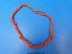 A three strand coral necklace of twisted design