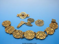 A gilt brooch set with a pierced balance cock with garnet cabochons and a similar bracelet made up