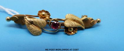A Victorian 9ct gold brooch set with a ruby with ivy decoration
