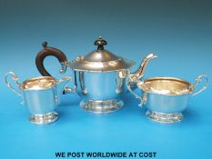 A hallmarked silver three-piece tea set with lip to edge,