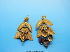 A pair of yellow metal earrings in the design of leaves and flowers set with garnets,