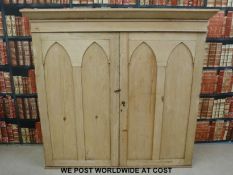 A pine housekeeping cupboard with Gothic style arches to the doors (H154, W163,