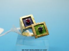 A yellow metal ring in  the form of two squares set with enamel, a ruby and a sapphire (size N, 9.