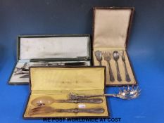 A cased pair of salad servers with white metal handles together with a carved carving set and a