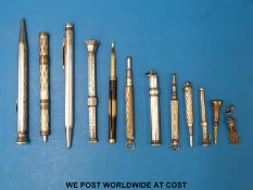 A hallmarked silver pencil, three white metal pens,
