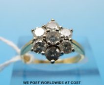 A yellow metal ring set with seven diamonds in a cluster (total 1ct,