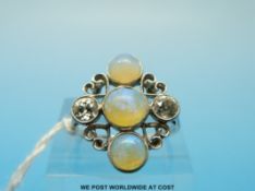 An 18ct white gold ring set with three opal cabochons and two Old English cut diamonds measuring
