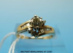 A 14ct gold ring set with a round brilliant cut diamond solitaire with baguette cut encrusted