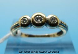 A 9ct gold ring set with three diamonds in a bezel setting (size P)