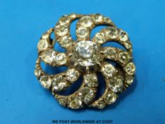 A silver brooch set with paste in a cluster