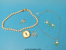 A single strand pink pearl necklace with matching earrings,