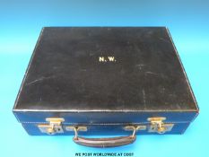 A leather gentleman's travelling vanity set comprising ivory backed brushes,