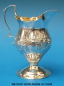 A Victorian hallmarked silver helmet-shaped cream jug with gilt wash interior, Ldn 1887,