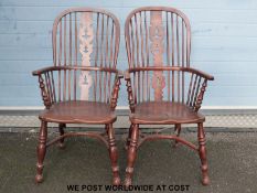A near pair of elm seated hoop back Windsor chairs with pierced splat backs and crinoline stretcher