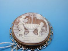 A large cameo depicting a women and cherub at a fountain in 9ct gold mount