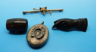 A yellow metal brooch in the form of a fox's head and riding crop,