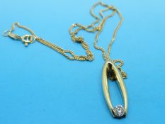 An 18ct gold pendant set with a round brilliant cut diamond in an oval design on an 18ct gold chain