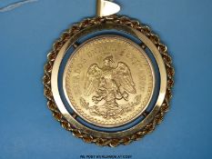 A gold Mexican 50 Pesos coin in a large yellow metal mount with rope decoration to the edge (52.