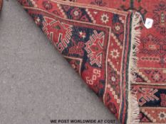 Three wool rugs, one geometric on pink ground (190cm x 118cm)  ,