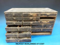 A small vintage set of drawers containing a quantity of wrist and pocket watch spares comprising