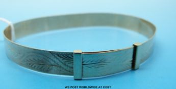 A 9ct gold bangle with chased decoration