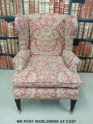 A probably late 19thc/ early 20thC wing back armchair with square tapering front legs on brass