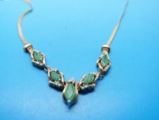 A 9ct gold necklace set with emeralds and diamonds