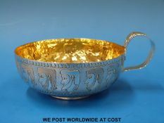 A hallmarked silver cup with engraved Egyptian heads and gilt wash interior, B'ham 1946,