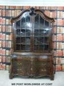 A continental 19thC style bookcase with carved scrolling top,