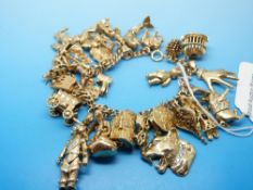 A 9ct gold bracelet with 27 charms some 18ct/ 9ct gold to include diamond set examples,