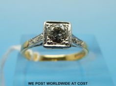 An Art Deco style 18ct gold ring set with a round brilliant cut diamond in a  square platinum