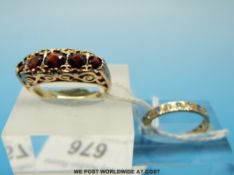 A 9ct gold ring set with five round cut garnets in a scrolling setting and a 9ct gold ring set with