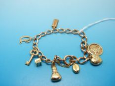 A 9ct gold charm bracelet with eight gold charms including a St Christopher, ingot etc (24.