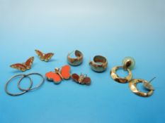 A yellow metal pendant set with agate in the shape of a butterfly with ruby eyes,