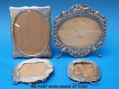 Four various white metal photograph frames including a pierced example,