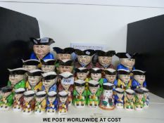 A large collection of graduated toby jugs and a book 'Devonmoor Art Pottery'